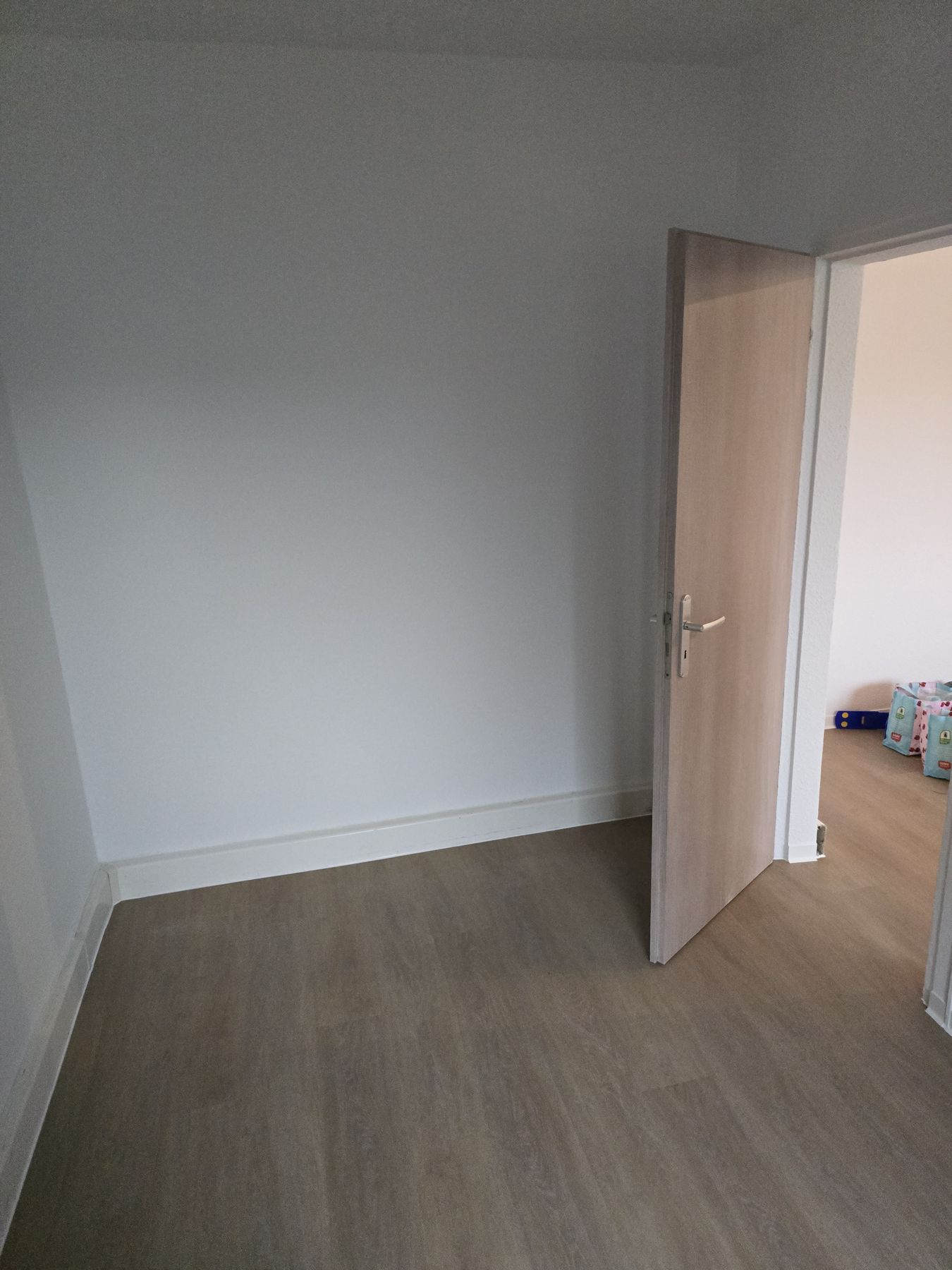 Fertig renovierter Raum mit weißen Wänden und neuem Designboden